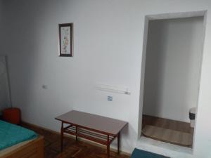 a room with a table and a bed and a door at Hostel Trajan in Donji Milanovac