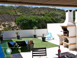 パタイアスにあるApartment at Praia Paredes de Vitória by book yourholiday ptの草の木のあるパティオ、植物のある暖炉