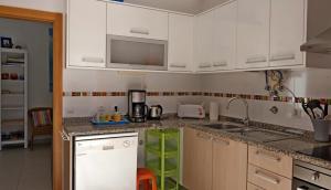 uma cozinha com armários brancos e um lavatório em Apartment at Praia Paredes de Vitória by book yourholiday pt em Pataias
