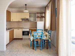 a kitchen with a table and chairs and a refrigerator at Apartments Summer Bloom in Krk