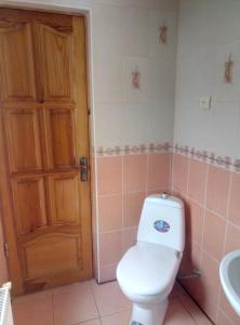 a bathroom with a white toilet and a sink at Park House in Pochayiv