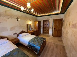 sypialnia z 2 łóżkami i drewnianym sufitem w obiekcie Yusuf Bey House w Göreme