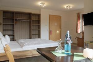 a bedroom with a bed and a table with a bottle of coke at Erlebnisgastronomie Lochmuhle in Eigeltingen