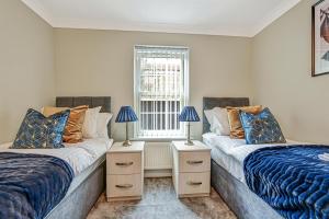 two beds in a room with two lamps at Deanway Serviced Apartments Chalfont St Giles By 360Stays in Chalfont Saint Giles