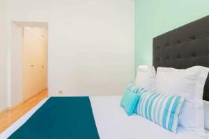 マドリードにあるEl Viso Smartのベッドルーム1室(青と白の枕が備わるベッド1台付)