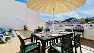 a table with chairs and an umbrella on a balcony at Liberdade by Check-in Portugal in Albufeira +14 photos