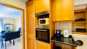 eine Küche mit einer Theke und eine Mikrowelle in der Unterkunft Liberdade by Check-in Portugal in Albufeira