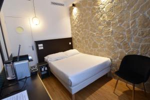 a bedroom with a bed and a stone wall at Hôtel Bonne Nouvelle in Paris