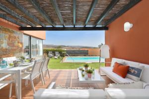 a patio with a table and chairs and a pool at Albatross by VillaGranCanaria in Maspalomas