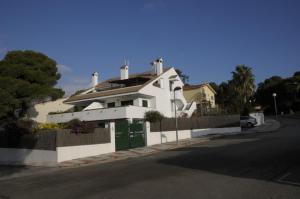 una casa blanca con una puerta verde en una calle en Encantador apartamento en S'Agaró-Platja de Aro, en S'Agaró