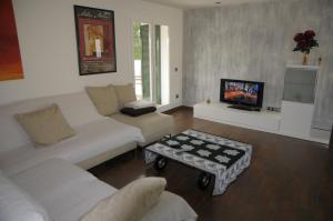 a living room with a white couch and a tv at Encantador apartamento en S'Agaró-Platja de Aro in S'Agaro