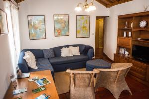 a living room with a blue couch and a table at Mosteiros Sea House in Mosteiros