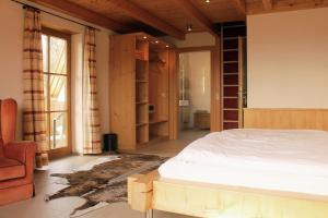 a bedroom with a bed and a chair and a window at Erlebnisgastronomie Lochmuhle in Eigeltingen