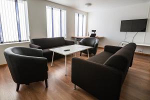 a waiting room with couches and a table and a tv at TorskenSenteret in Torsken