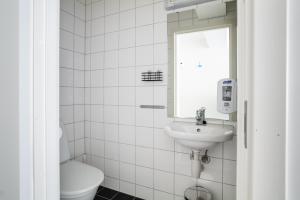 TorskenSenteret في Torsken: حمام أبيض مع حوض ومرحاض