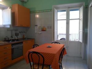a kitchen with a table and a kitchen with a window at Il Giardino Del Purgatorio in Marsala