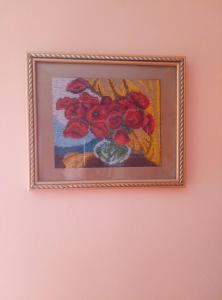 a picture of a painting of red flowers on a wall at Park House in Pochayiv