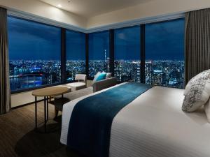 
a hotel room with two beds and a large window at Mitsui Garden Hotel Toyosu BAYSIDE CROSS Tokyo in Tokyo
