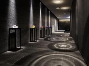 a hallway with black walls and a row of tables at Mitsui Garden Hotel Toyosu Premier - Tokyo in Tokyo
