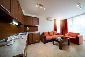 a kitchen and living room with a couch and a table at Aurelia Beach Complex in Ravda