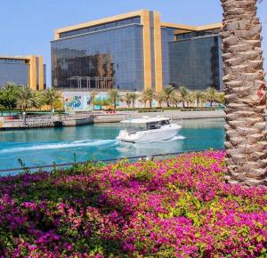 a boat in a river in front of a building at شقق نسيم البحر in King Abdullah Economic City