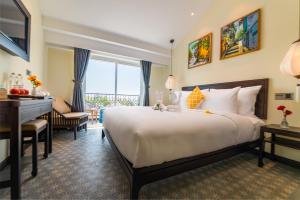 Postel nebo postele na pokoji v ubytování Hoi An Merrily De Art Hotel + 37 fotografií