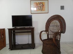 a television sitting on a stand next to a chair at Avenida Apart "Nuez de la Isla II" in Paraná