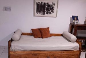 a bed with white sheets and brown pillows at Avenida Apart "Nuez de la Isla II" in Paraná