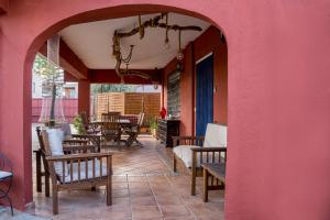 a patio with tables and chairs and a pink wall at Fileta playa Castellón in Castellón de la Plana