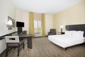 um quarto de hotel com uma cama grande e uma secretária em Candlewood Suites Longmont - Boulder Area, an IHG Hotel em Longmont