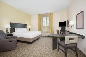 a hotel room with a bed and a desk at Candlewood Suites Longmont, an IHG Hotel in Longmont