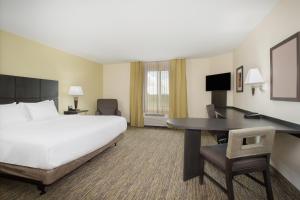 a hotel room with a bed and a desk at Candlewood Suites Longmont - Boulder Area by IHG in Longmont +77 photos