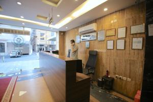 a man standing at a bar in a lobby at Jawharat Layali (For Families Only) in Jeddah