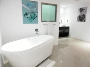 a white bathroom with a tub and a sink at Essenzia de Cancun in Canc&uacute;n