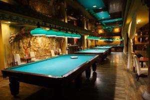 a row of billiard tables in a room with a row at Misteriya Hotel in Kharkiv