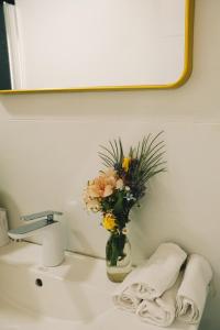 um vaso de flores sentado em cima de um lavatório de casa de banho em רוח מדבר - Desert wind em Dimona