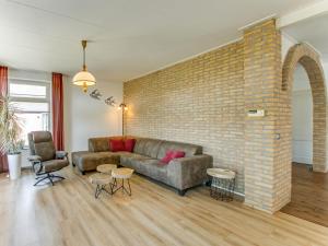 un soggiorno con divano e muro di mattoni di Classy Holiday Home in Langezwaag with Terrace a Langezwaag