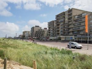 un coche blanco estacionado frente a un edificio en Apartment at the promenade and beach, en Noordwijk