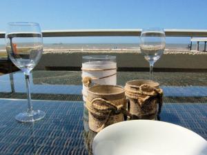 2 copas de vino en una mesa con vistas a la playa en Apartment at the promenade and beach, en Noordwijk
