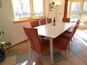 une salle à manger avec une table et des chaises blanches dans l'établissement Peaceful Mansion in De Cocksdorp with Terrace, à De Cocksdorp