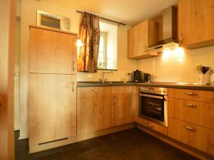 a kitchen with wooden cabinets and a sink at Holiday Home in Slenaken near Forest in Slenaken