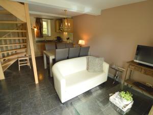 - un salon avec une chaise blanche et une table dans l'établissement Comfy Holiday Home near Forest in Slenaken, à Slenaken