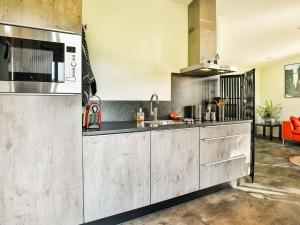 uma cozinha com um lavatório e um micro-ondas em Fantastic modern vacation home with views em Tripscompagnie