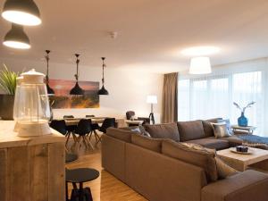 een woonkamer met een bank en een tafel bij Apartment overlooking the Scheveningen harbor in Scheveningen