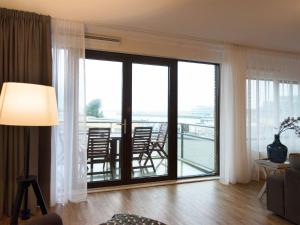 een woonkamer met een grote glazen schuifdeur bij Apartment overlooking the Scheveningen harbor in Scheveningen