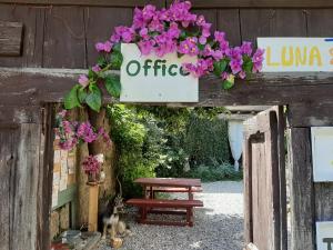 Un segno che dice offerta con fiori viola e una panchina di Agriturismo Conte Brunello a Salò