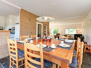 uma sala de jantar e sala de estar com uma mesa de madeira e cadeiras em Luxury Holiday Home with Terrace em Beek