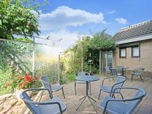 een patio met stoelen en tafels in een tuin bij Luxury Holiday Home with Terrace in Beek