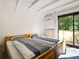 two beds in a room with a window at Luxury Holiday Home with Terrace in Beek