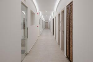 a long hallway with white walls and white floors and ceilings at Aliv stone suites & spa in Agios Nikolaos